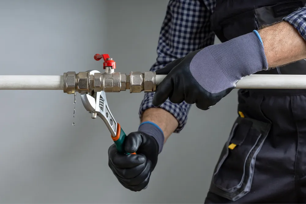 Wrench tightening a pipe fitting during a repair — illustrative stock photo, not this site's own work